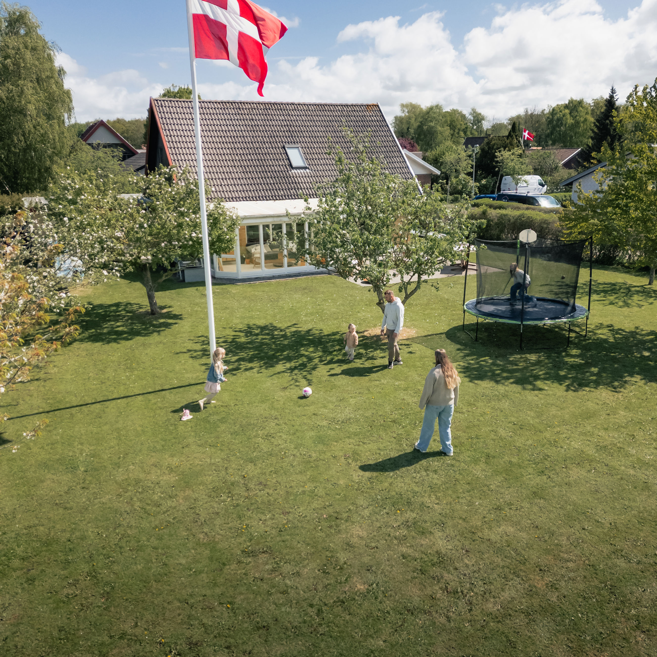 Familie fra Bogense hjemme i deres have og spiller fodbold.