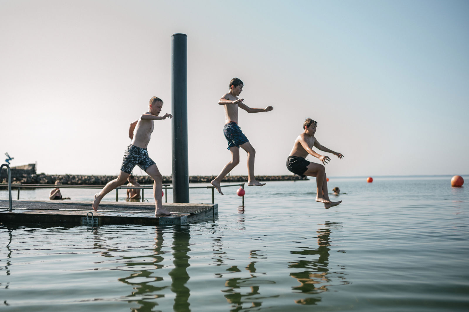 Tre unge drenge, der bader ved Bogense Søbad.