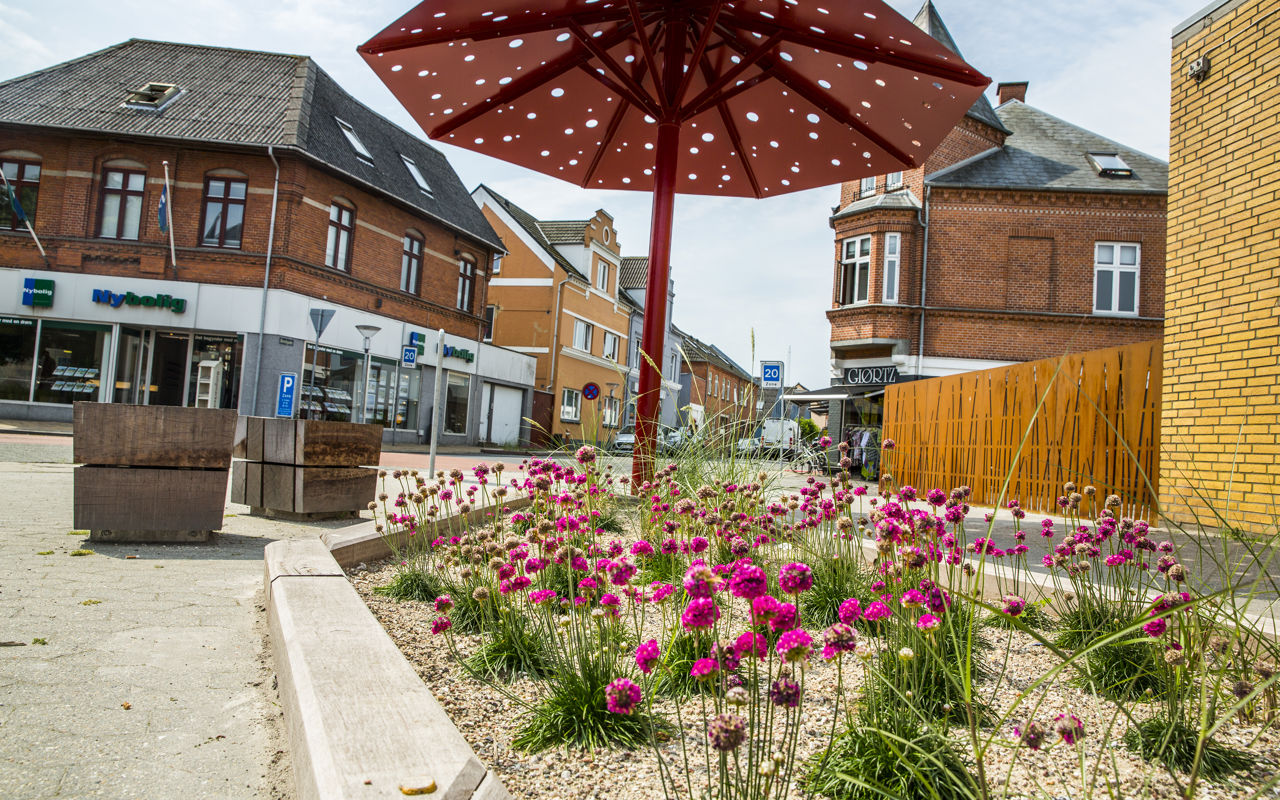 Billede fra Otterup bymidte med blomsterkumme i forgrunden.
