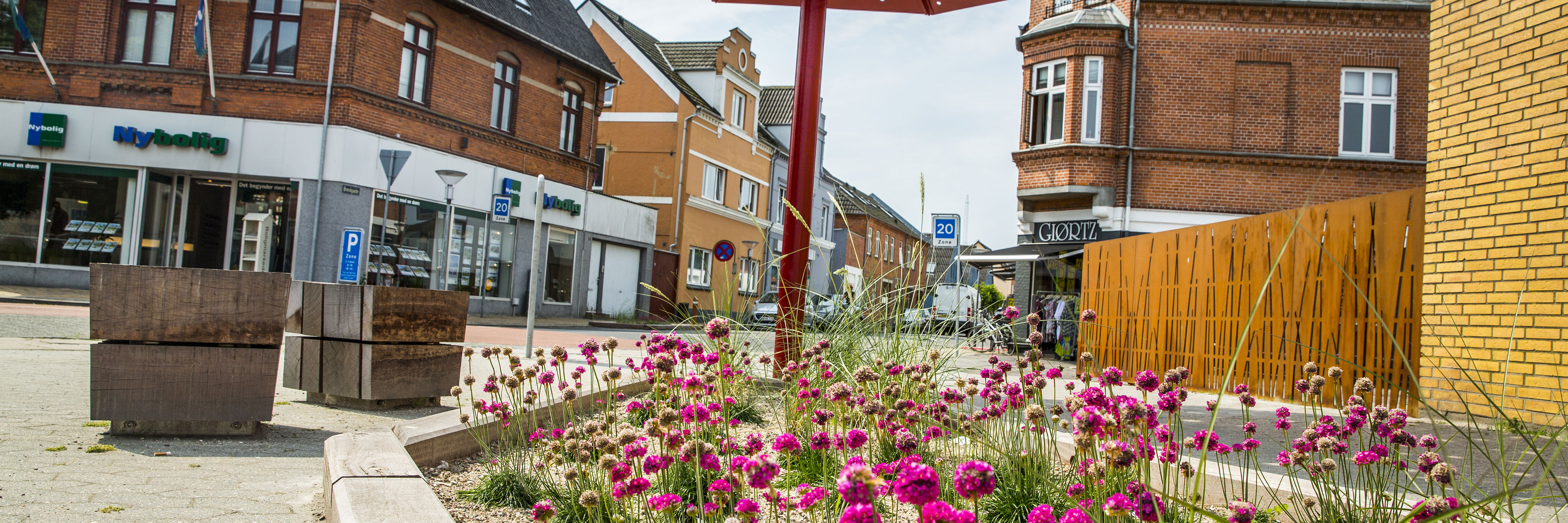 Billede fra Otterup bymidte med blomsterkumme i forgrunden.