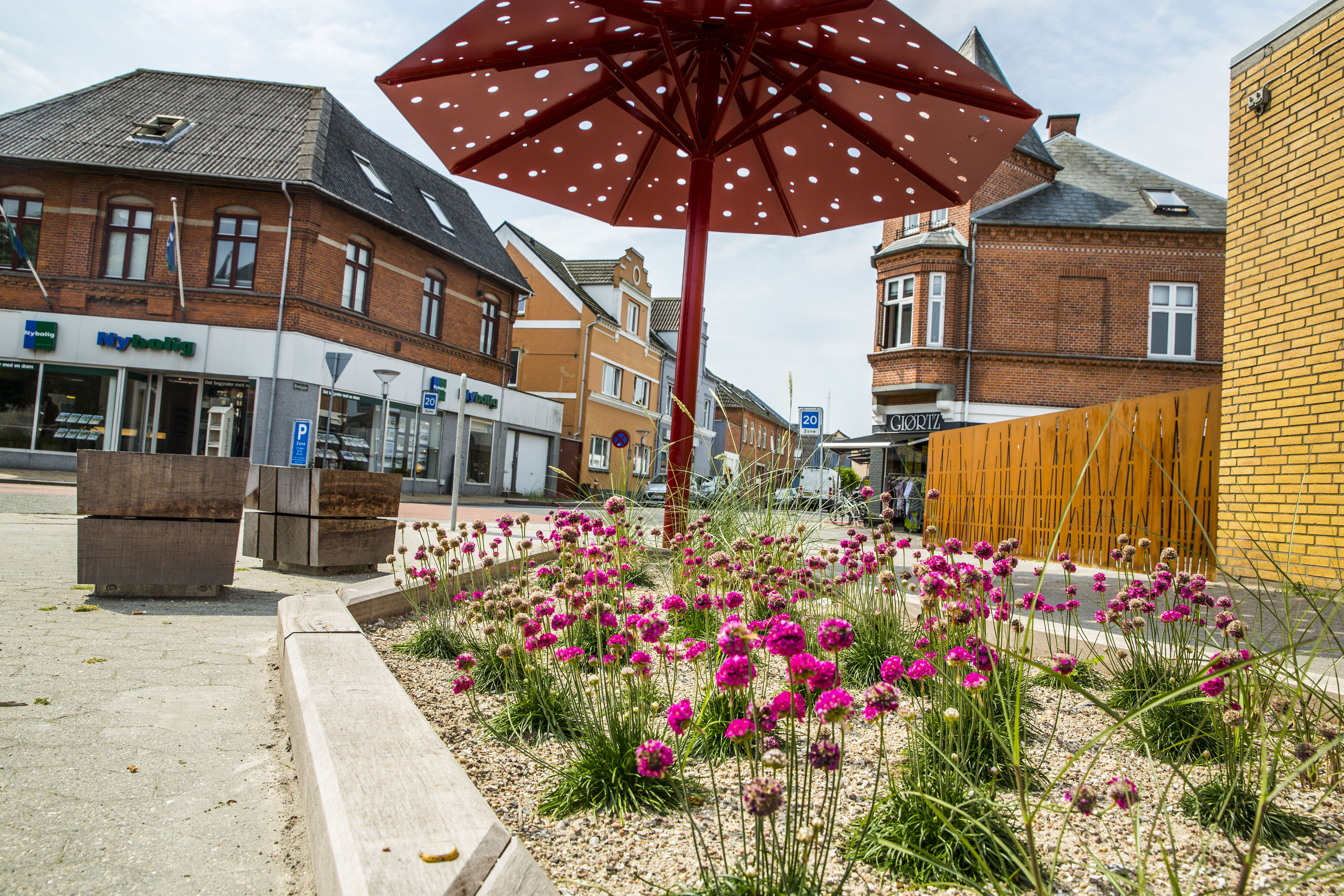 Billede fra Otterup bymidte med blomsterkumme i forgrunden.