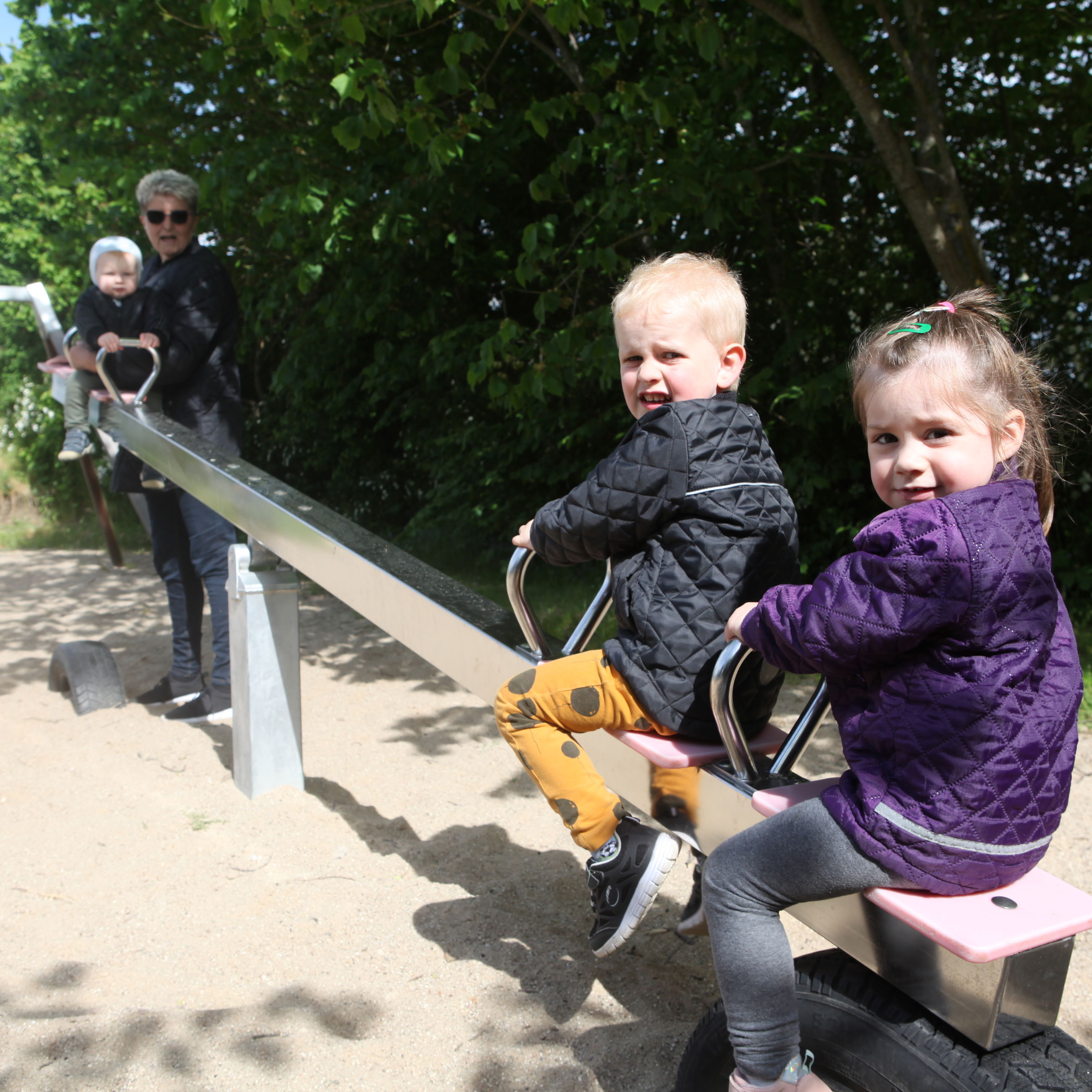 Dagplejere på tur på legeplads med børnene.