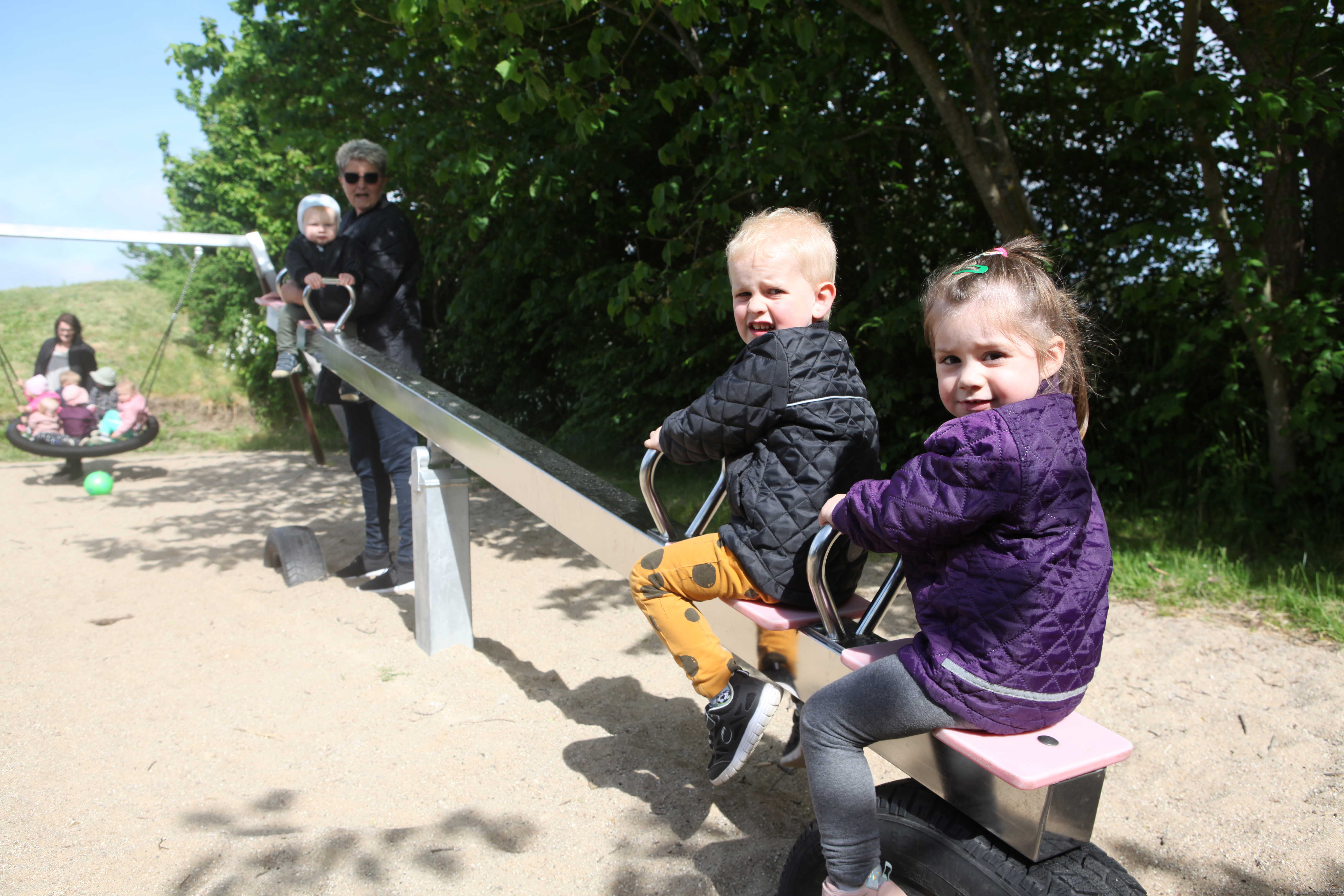 Dagplejere på tur på legeplads med børnene.