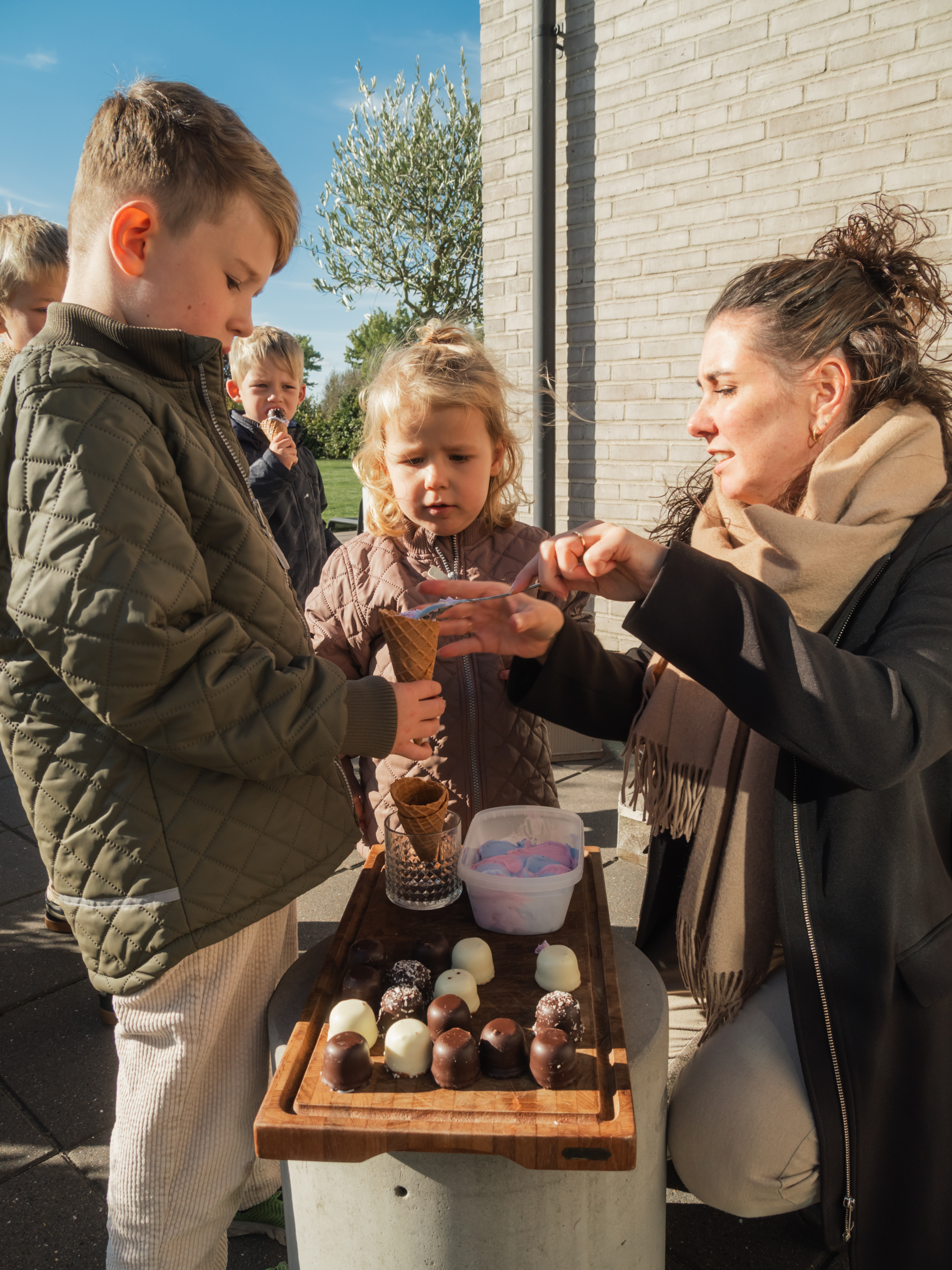 Billede af børn, der får hjemmelavede isvafler som snack i haven i et nybyggerkvarter i Otterup - efterår 2024.