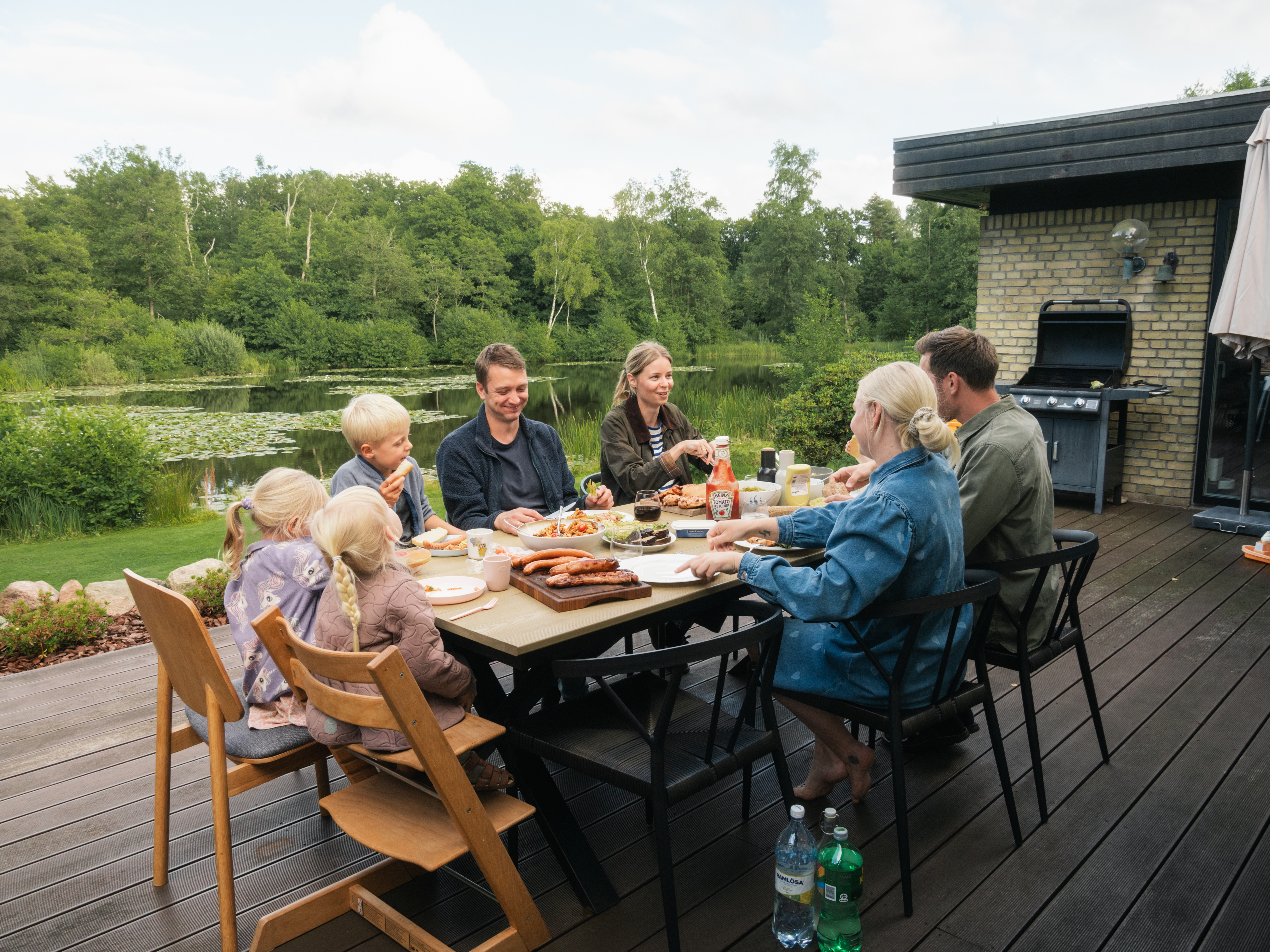 To familier, der spiser aftensmad sammen en sommeraften i Morud.