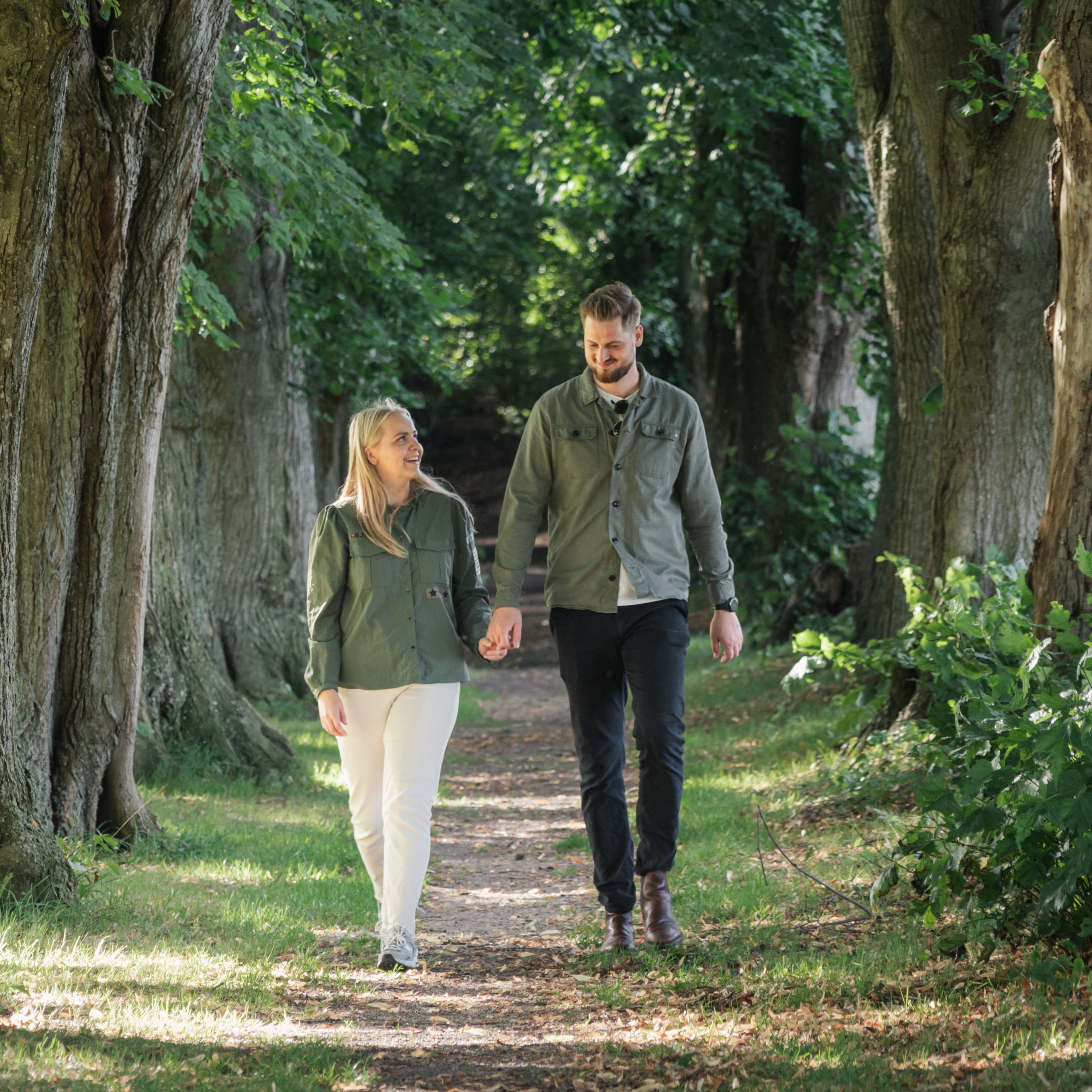 Par, der går hånd i hånd langs alléen i Glavendruplunden på Nordfyn.
